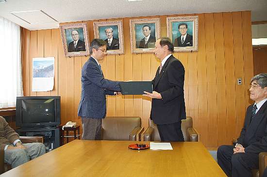 協定書を交換する北海道大学 渡部教授と島市長(平成17年当時)